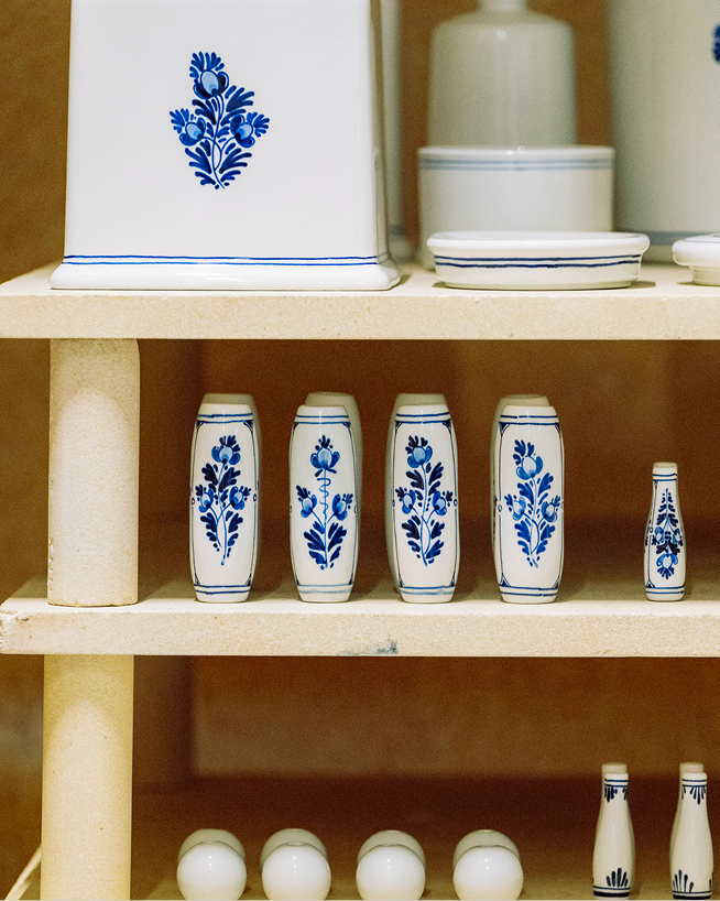 Hand-painted Royal Delft handles and accessories on a shelf